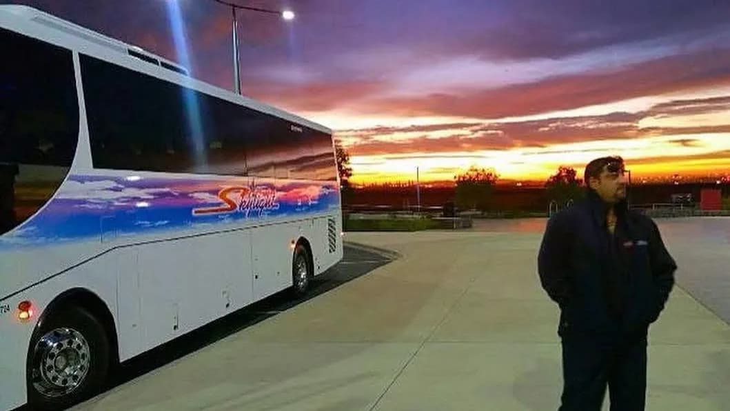 A Skylight Bus Lines driver beside their coach at the end of the day